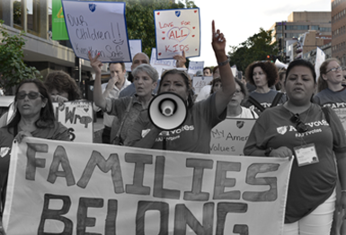 Photo of AFT members marching with AFT Executive Vice President Evelyn DeJesus. Sign reads "Families Belong Together"