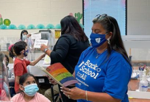 Photo of AFT Executive Vice President Evelyn DeJesus reading a book to students